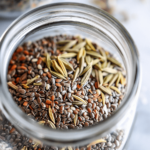 A jar containing hydrated seeds including chia and fennel in water, used for a bariatric seed drink.