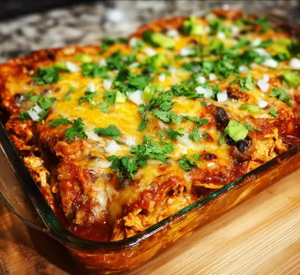 Cheesy chicken enchilada casserole with tortillas, chicken, and sauce baked to perfection