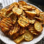 Crispy air fryer spicy dill pickle chips served with dipping sauce.