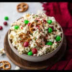 Festive Christmas popcorn coated in white chocolate with sprinkles and candy.
