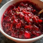 Homemade honey bourbon cranberry sauce with orange zest in a bowl.