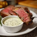 Creamy horseradish sauce in a bowl served next to sliced prime rib