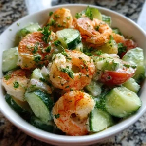 Fresh cucumber shrimp salad with herbs and lemon dressing in a white bowl