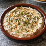 Jalapeno cream cheese dip in a baking dish with melted cheese
