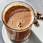 Chocolate smoothie healthy recipe served in a glass with chocolate shavings