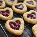 Freshly baked heart jam cookies on a tray