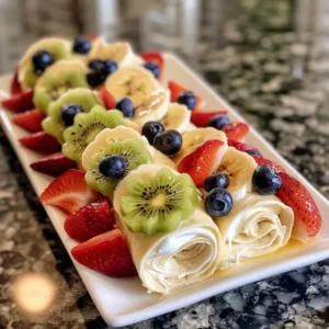 Cheesecake Fruit Salad Roll Ups on a white plate with fresh fruits