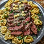 Garlic steak tortellini served in a white bowl with parsley garnish