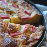 Slice of rhubarb custard kuchen served with whipped cream