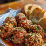 Baked meatballs in marinara sauce served with spaghetti on a plate